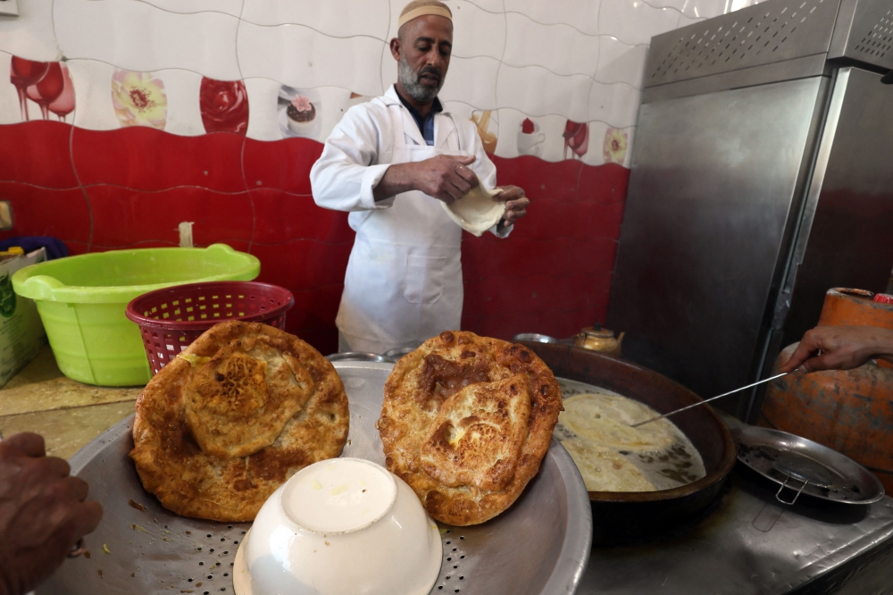 An employee prepares sfinz, a spongy fried bread that can be served plain or with eggs, in Tripoli on March 14, 2024, during the Muslim holy fasting month of Ramadan. — AFP pic