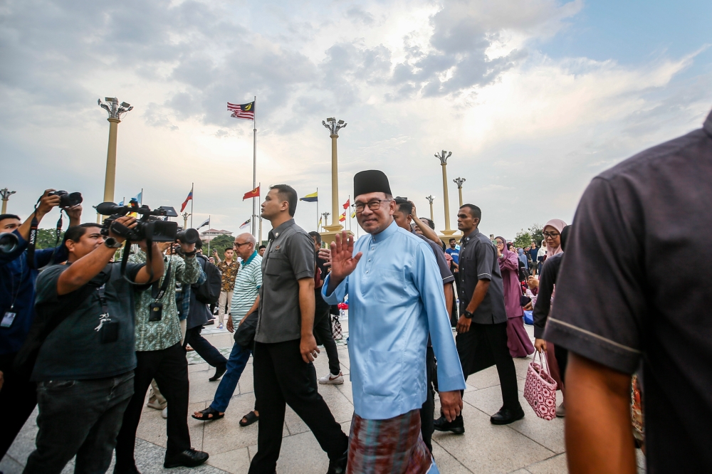 Prime Minister Datuk Seri Anwar Ibrahim waves to the crowd at the Madani breaking of fast event at Dataran Putra in Putrajaya, March 28, 2024. — Picture by Hari Anggara