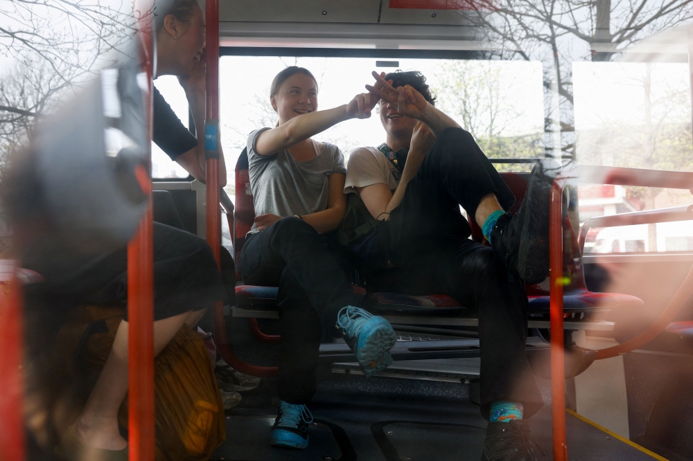 Climate activist Greta Thunberg gestures as she sits in a bus with people detained by police, on the day they try to block the A12 highway to ensure that the Dutch government stops subsidies for fossil fuels, in The Hague April 6, 2024. — Reuters pic  