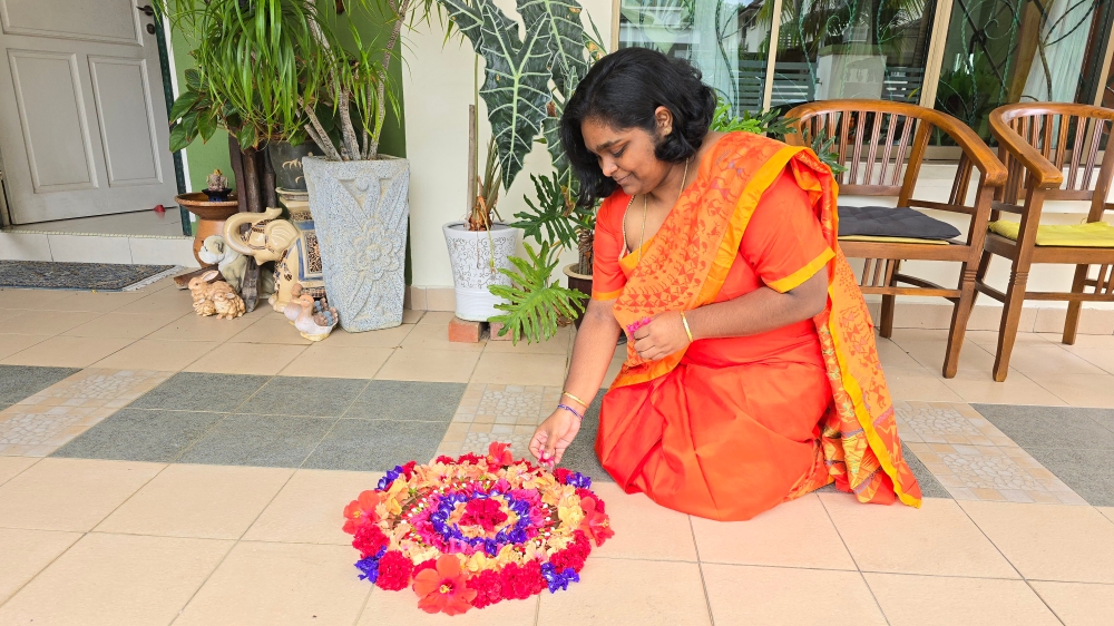 Dr Hema Dhaarsinii Sankaran prepares a pookalam at her residence in Johor Baru to usher in Vishu on Sunday. — Picture courtesy by Renitha Ramoo