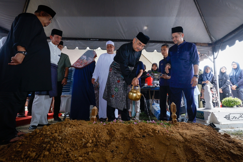 Melaka Yang Dipertua Negeri Tun Mohd Ali Mohd Rustam sprinkles water on the grave of late Melaka State Secretary Datuk Zaidi Johari who was buried at Tebong Islamic Cemetery, April 19, 2024. — Bernama pic 