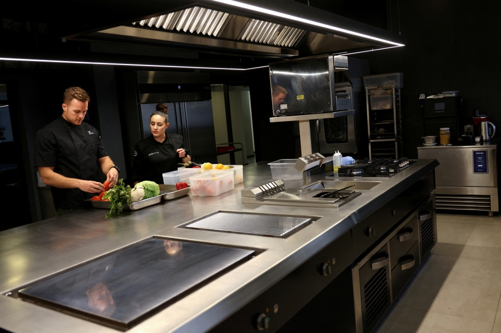 Bernardo Moltedo, culinary scientist in the AI area, and Flor Villagra, AI developer chef, of the plant-based food company NotCo, sort vegetables for their recreated veggie-based turtle soup developed with AI at the NotCo kitchen-laboratory, in Santiago April 19, 2024. — Reuters pic  