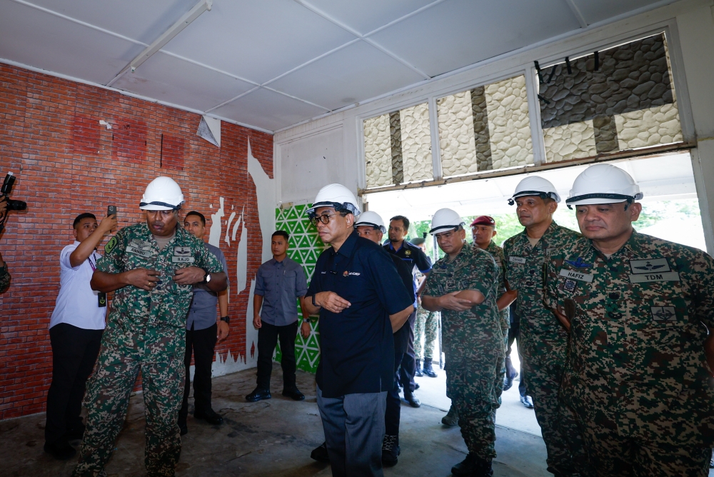 Defence Minister Datuk Seri Mohamed Khaled Nordin accompanied by Chief of Army General Tan Sri Muhammad Hafizuddeain Jantan (right) during a visit to a Military Family Home (RKAT) undergoing refurbishment as part of his working visit to Camp Terendak, Sungai Udang, Melaka, May 2, 2024. — Bernama pic 