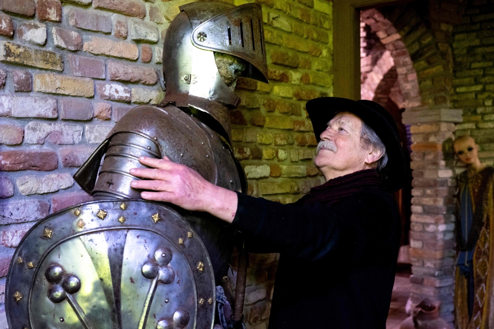 Gerry Halman, aka Lord Gregarious, stands next to a mannequin dressed in combat armor in his 