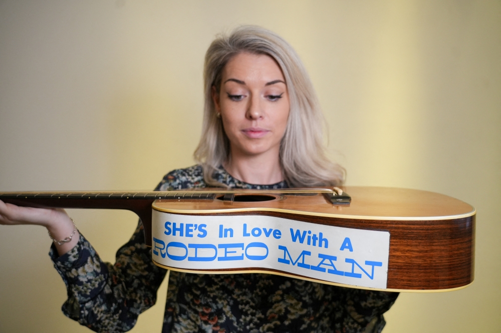 Claire Tole-Moir, head of Bonham's Popular Culture department, poses for a photograph with Eric Clapton's 1974 000-28 Martin acoustic guitar, on which he wrote the song ‘Wonderful Tonight’, at Bonhams auction house, ahead of the ‘Rock, Pop & Film’ auction on June 12, in London May 13, 2024. — Reuters pic