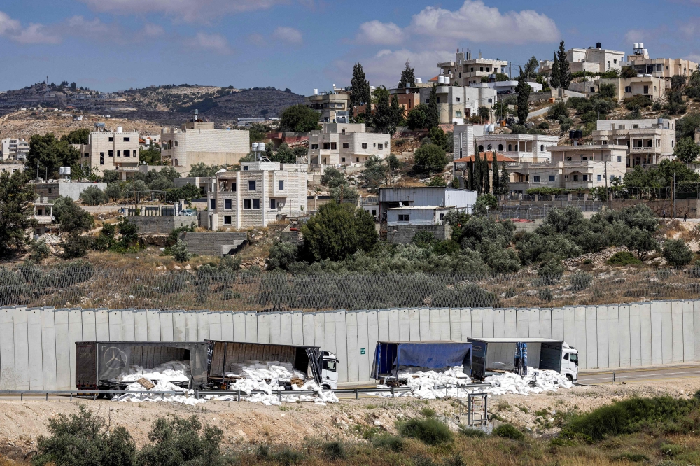 Des camions-remorques endommagés qui transportaient des fournitures d'aide humanitaire ont été vandalisés par des militants israéliens de droite.  — Photo AFP