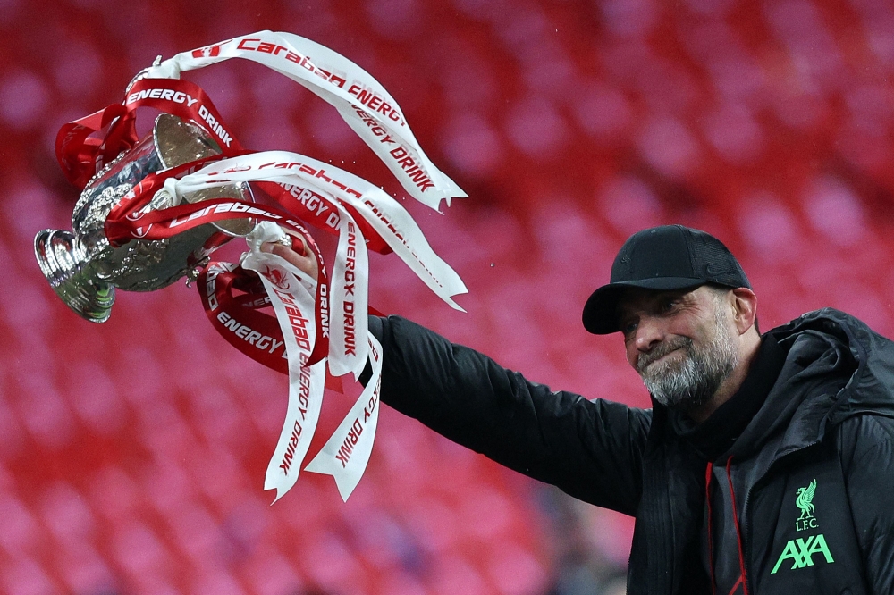 Liverpool's German manager Jurgen Klopp celebrates with the trophy after winning the English FA Cup final football match between Chelsea and Liverpool, at Wembley stadium in London May 14, 2022. — AFP pic