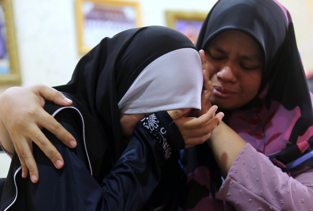 The sisters of late Constable Ahmad Azza Fahmi Azhar (from right) Nur Azza Assyaqiren, 29, and Nur Azza Assyufia, 16, are seen at their home at Kampung Poh in Tapah May 17, 2024. — Bernama pic