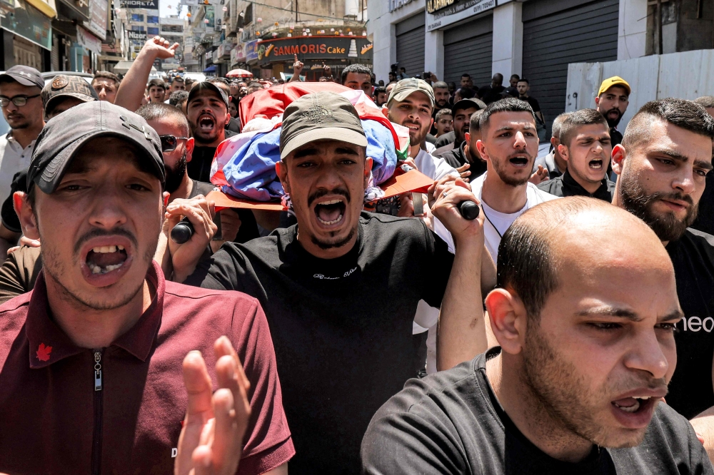 Mourners carry one of the bodies of three Palestinian men killed during an Israeli army raid in Tulkarem in the occupied West Bank, during their funeral on May 16, 2024. — AFP pic