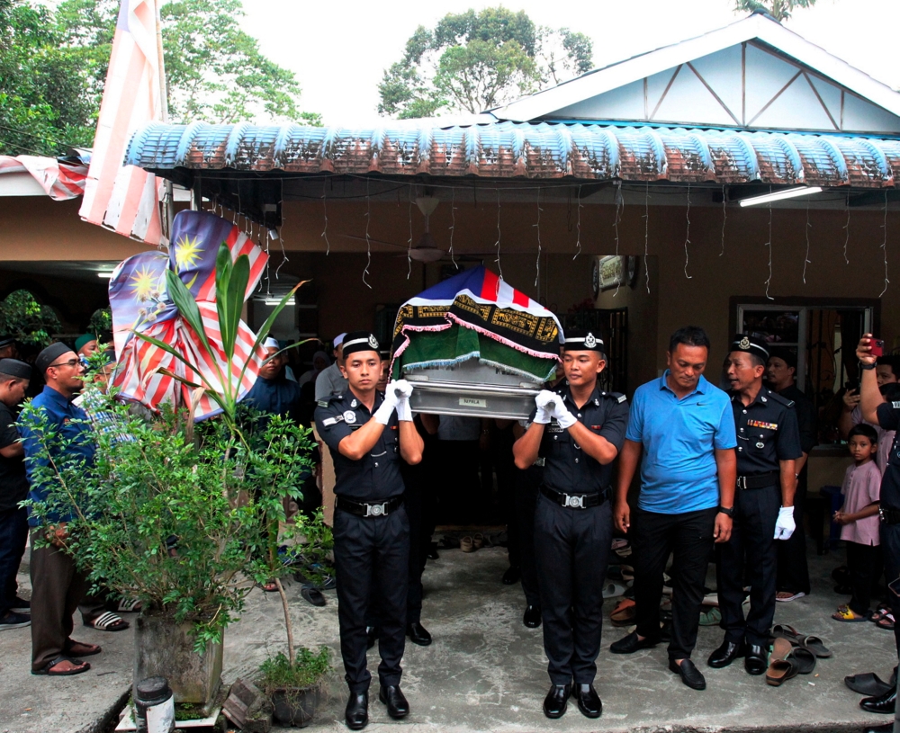 Mourners are seen at the residence of Constable Ahmad Azza Fahmi Azhar in Kampung Poh Tambahan, Bidor when his body arrived from Johor May 18, 2024. — Bernama pic