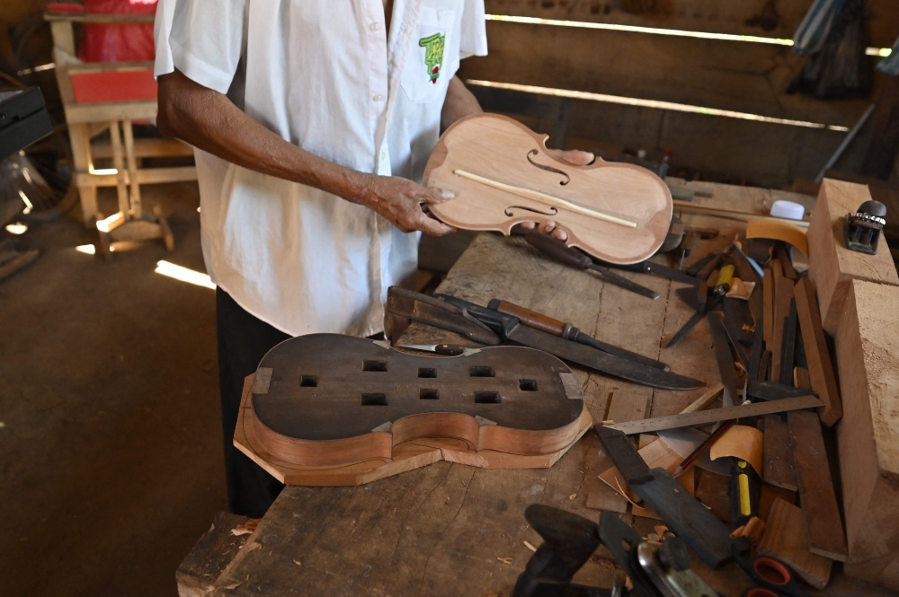 Hildeberto Oreyai works on a piece of wood to make a violin in the town of Urubicha, Bolivia April 22, 2024. — AFP pic