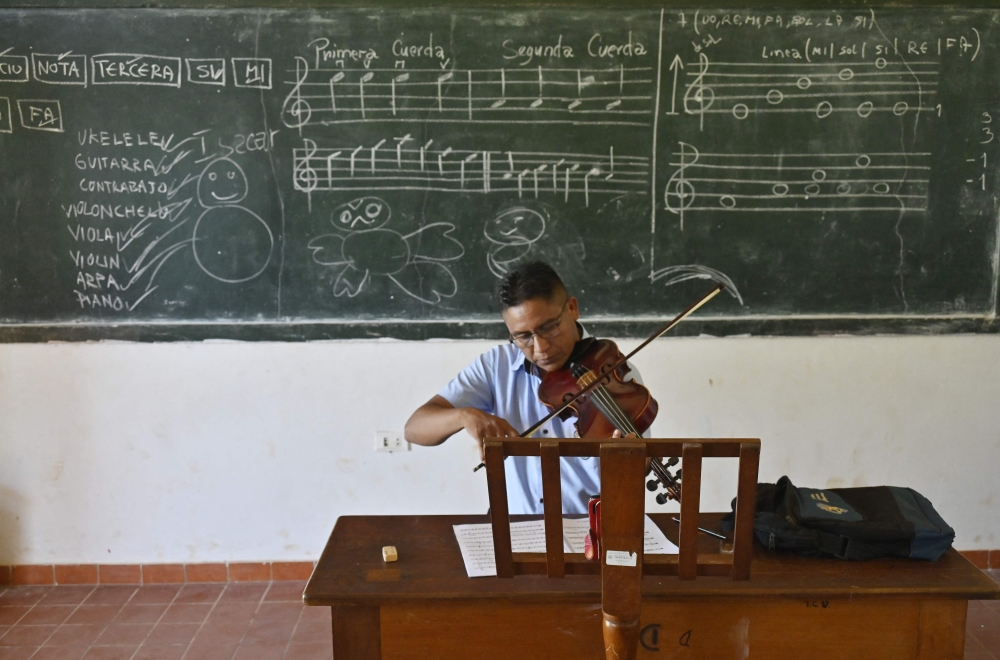 Vidal Uraba, a teacher at the Instituto de Formacion Artistica Coro y Orquesta Urubicha, plays the violin, in Urubicha April 22, 2024. — AFP pic