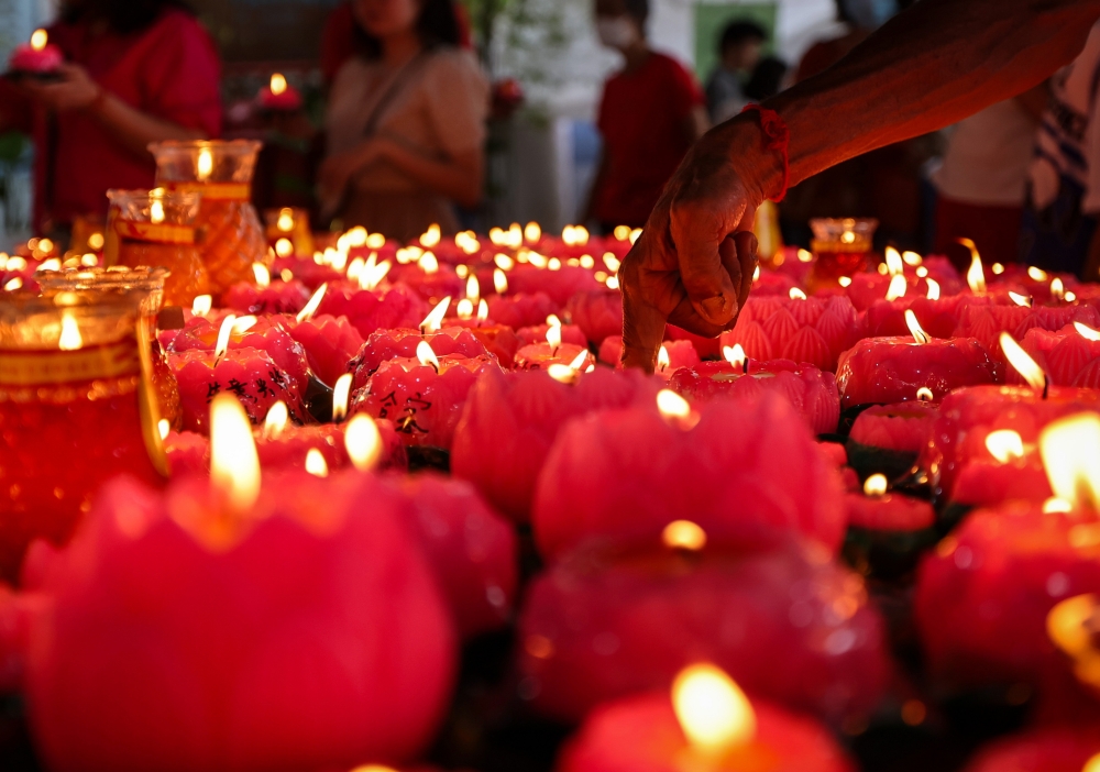 Devoetees light lotus-shaped candles during Wesak Day celebrations at the Malaysian Buddhist Association along Burma Road, May 22, 2024. — Bernama
