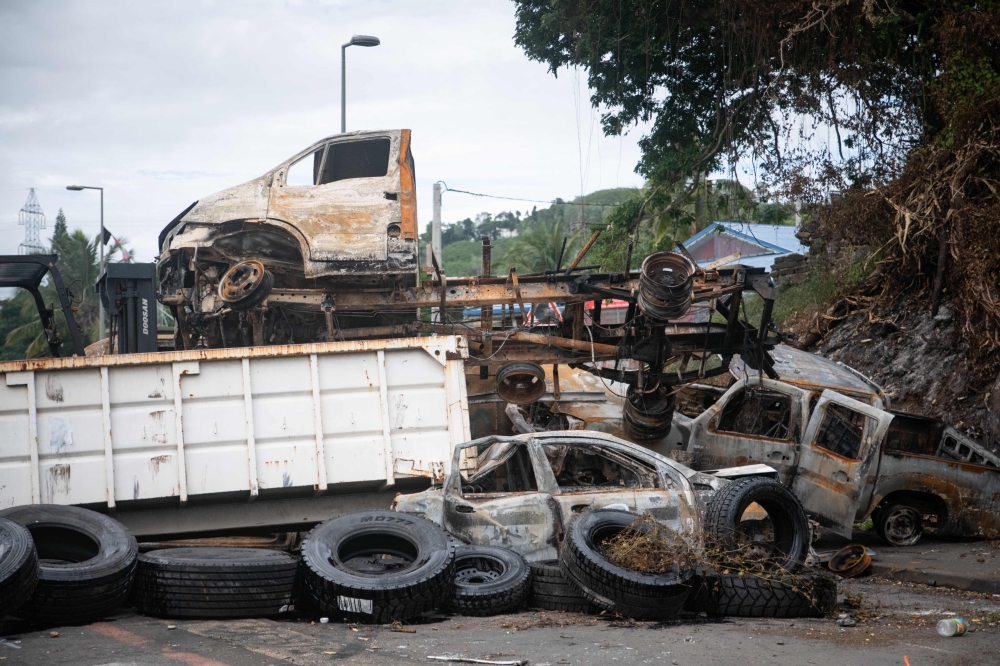 Burnt vehicles used as roadblocks. — AFP pic