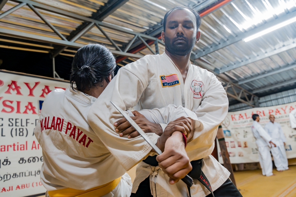 Master Mahenthiran Natarajan demonstrating a hand lock technique to a student. — Picture by Raymond Manuel