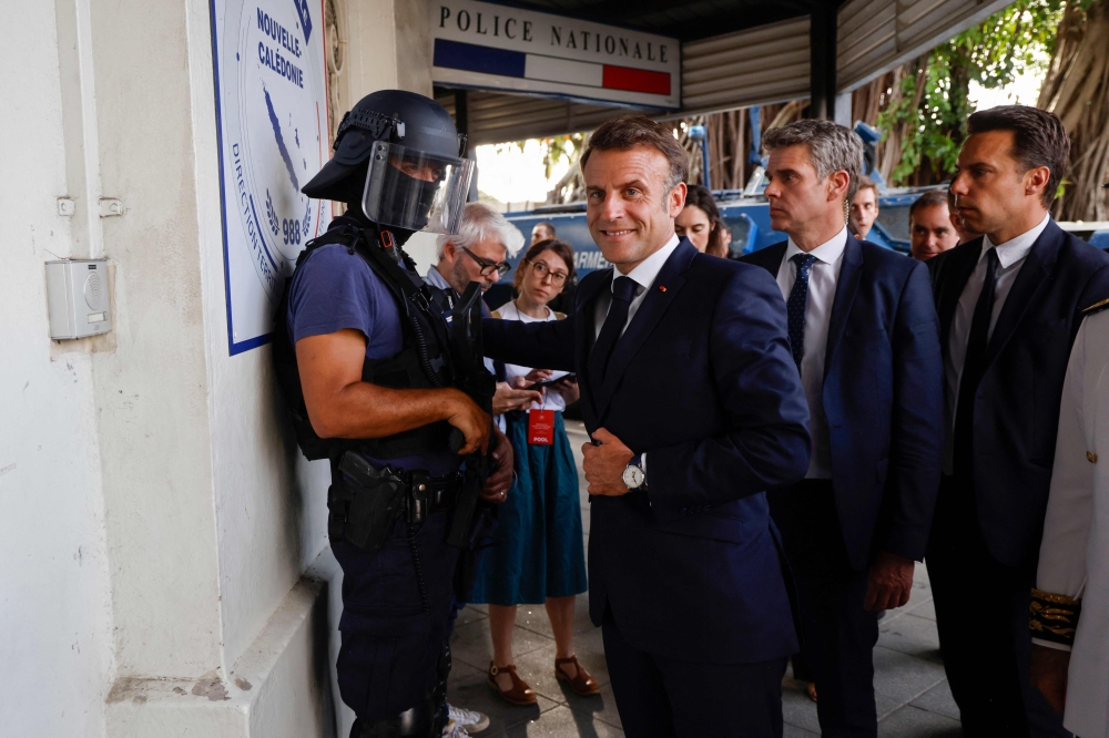 French President Emmanuel Macron (centre) arrives at the central police station in Noumea, France's Pacific territory of New Caledonia May 23, 2024. — Ludovic Marin/Pool/AFP pic 
