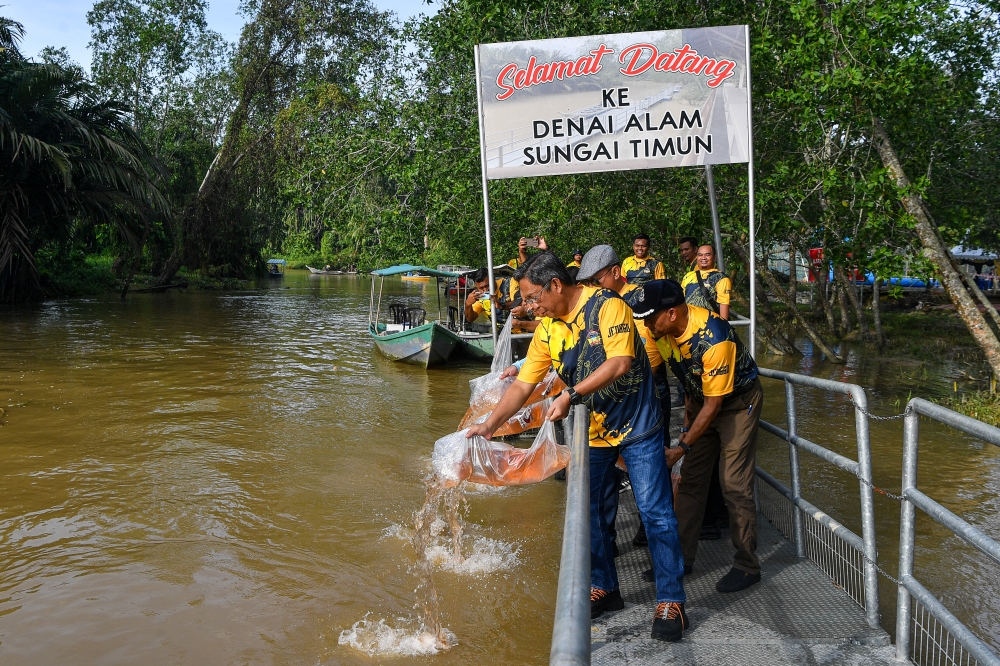 Negeri Sembilan Agriculture, Food Security and Cost of Living Action Committee chairman Datuk Seri Jalaluddin Alias (front) releases juvenile blue spiny lobster seeds at the ‘Sopit Biru’ Sungai Timun Programme in Rembau May 25, 2024. — Bernama pic