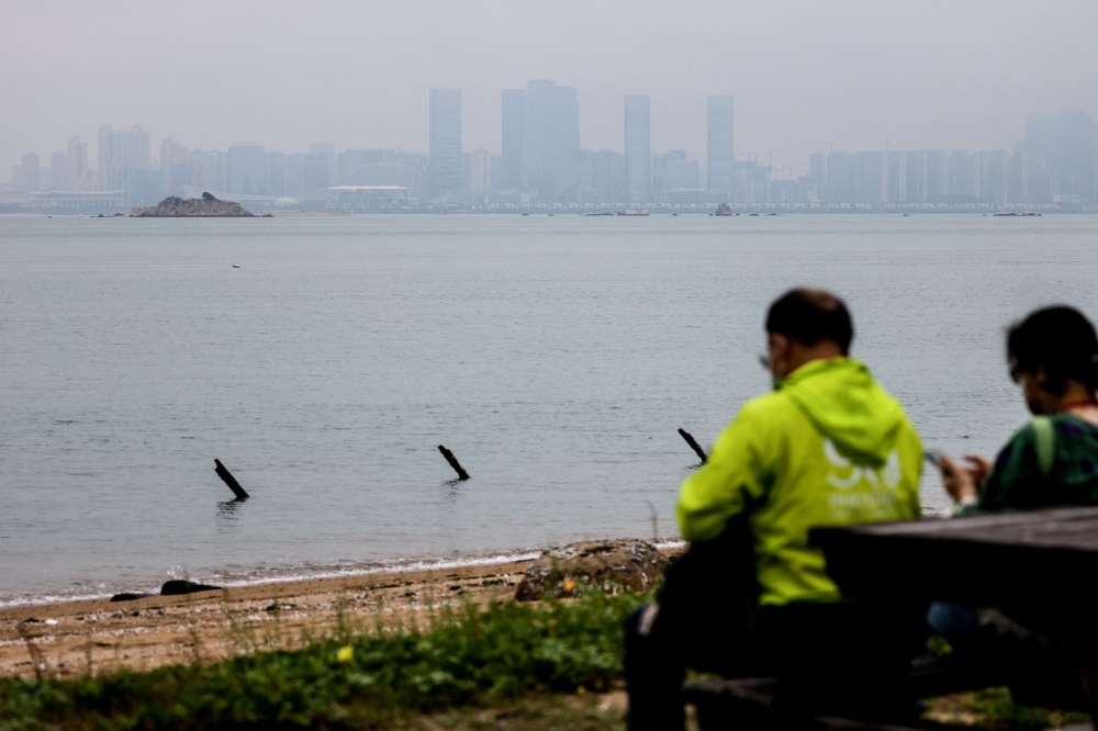 Tourists look at the Chinese city of Xiamen from Shuang Kou Coastal Park in Kinmen May 23, 2024. — AFP pic