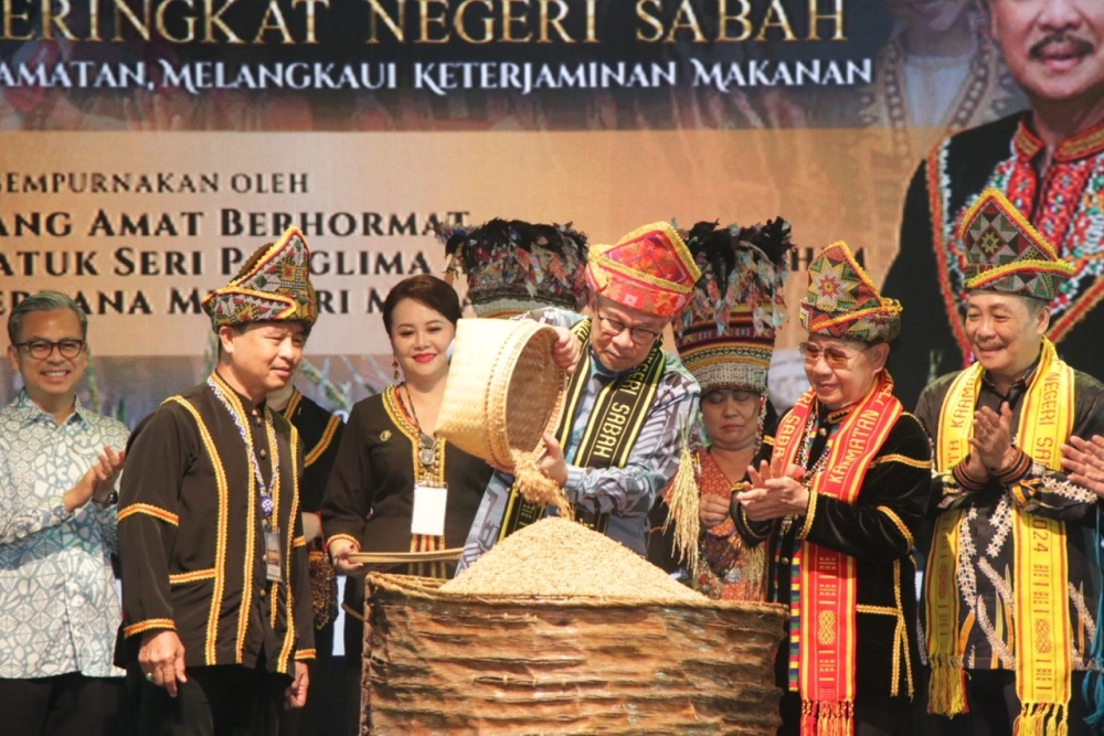 NO PIX CREDIT PLSAnwar pours raw rice grains into a container in a symbolic gesture at the closing ceremony of the Ka’amatan festival in Kota Kinabalu May 31, 2024. 