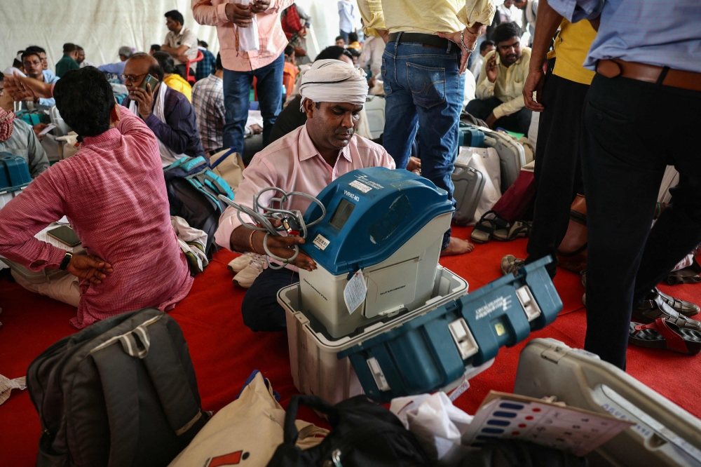 A polling officer checks a Voter Verifiable Paper Audit Trail (VVPAT) machine at a distribution centre in Varanasi on May 31, 2024, on the eve of the seventh and final phase of voting in India's general election. — AFP pic