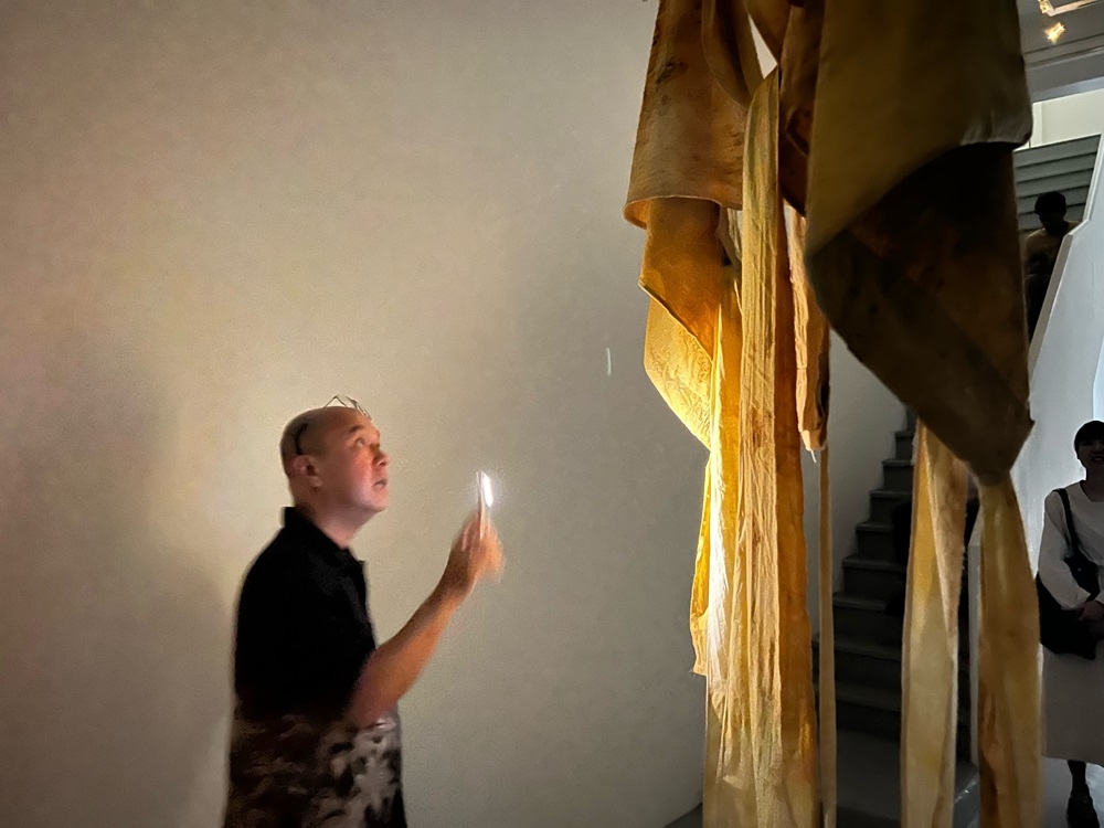 Leong Kwong Yee shines a light on the fabric artwork by Dan Lie that represents death and grief. ― Picture by Opalyn Mok