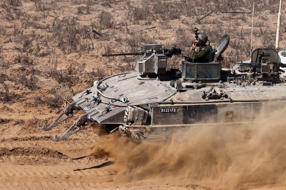 Israeli soldiers man an armoured vehicle operating near the border with the Gaza Strip on May 30, 2024, amid the ongoing conflict between Israel and the Palestinian Hamas movement. — AFP pic