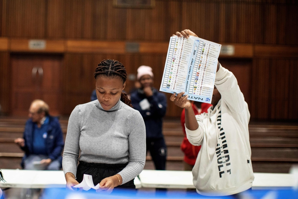 An Electoral Commission of South Africa (IEC) official holds up a marked ballot during the vote counting process at the Norwood school polling station in Durban on May 29, 2024, during South Africa? general election. — AFP pic