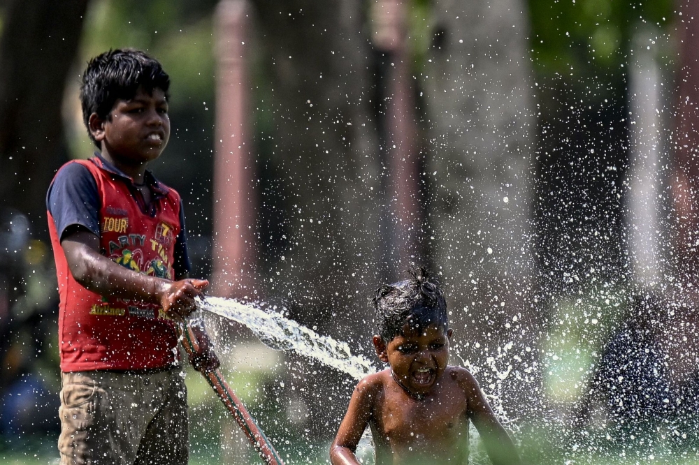 File photo of children playing with water during a hot summer day amid severe heatwave in New Delhi on May 31, 2024. — AFP pic