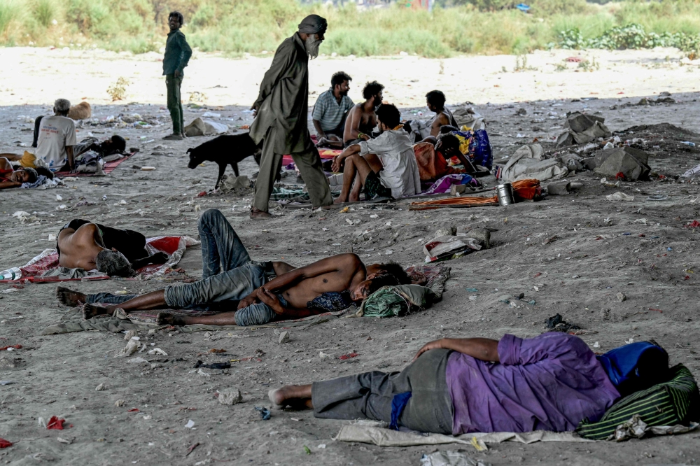 File photo of homeless people seen resting under a flyover on the banks of river Yamuna to shield themselves from the sun during a hot summer afternoon amid severe heatwave in New Delhi on May 31, 2024. — AFP pic