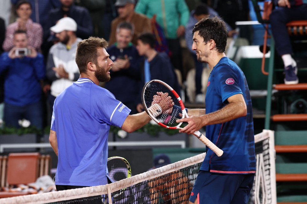 File photo of France’s Corentin Moutet (left) shaking hands with Austria’s Sebastian Ofner at the end of their men's singles match on Court Suzanne-Lenglen on day six of the French Open tennis tournament at the Roland Garros Complex in Paris on May 31, 2024. — AFP pic