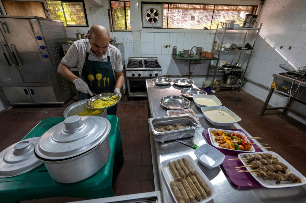 A Sudanese chef traditional food at a restaurant run by a businesswoman who relocated to the Egyptian capital Cairo after fleeing the ongoing war in Sudan May 21, 2024. — AFP pic