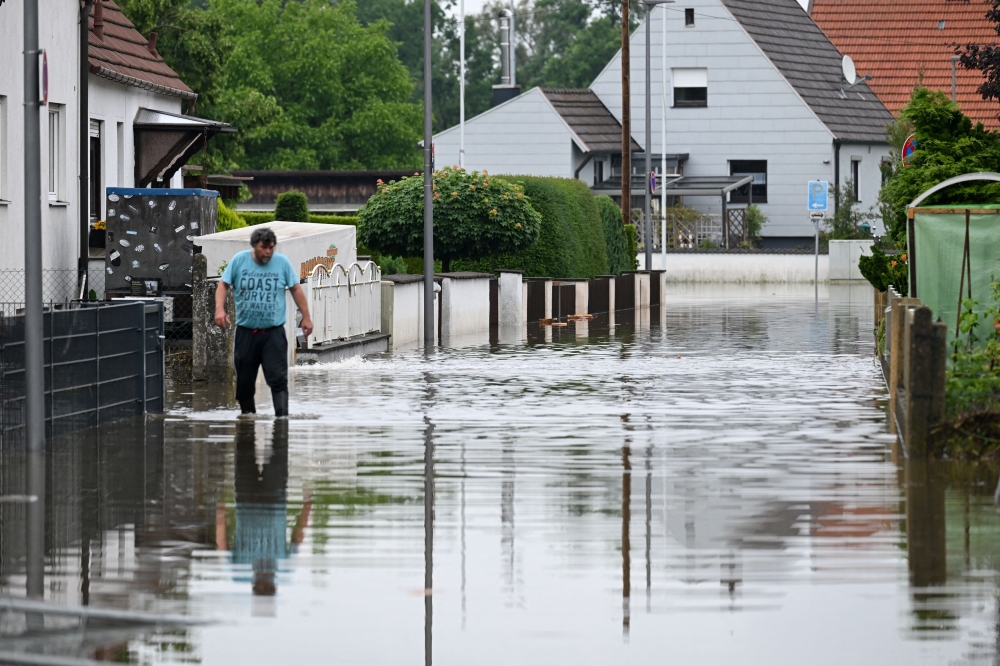 A man walks through a flooded area in Reichertshofen, near Ingolstadt, Germany, June 3, 2024. — Reuters pic  