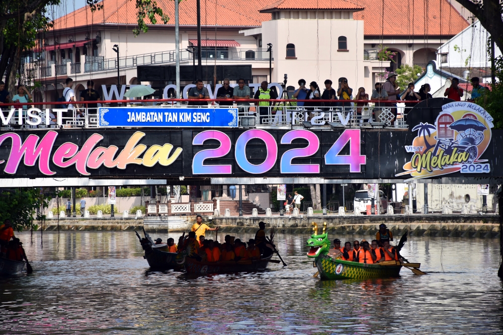 People watch the Melaka Dragon Boat Parade 2024 along Sungai Melaka June 8, 2024. — Bernama pic