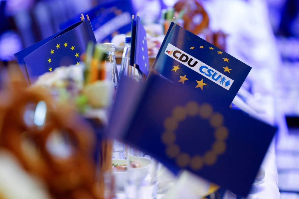 Pretzel and flags of the European Union with logos of CDU and CSU parties are pictured prior to the start of the last rally for European elections of German conservative party (CDU) and in Munich, southern Germany, on June 7, 2024. ― AFP pic