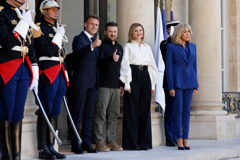 File photo of France’s President Emmanuel Macron (centre to left) and his wife Brigitte Macron (right) greeting Ukraine's President Volodymyr Zelensky (centre) and his wife Olena Zelenska (second right) prioer to their bilateral meeting at the Elysee Palace in Paris on June 7, 2024. ― AFP pic