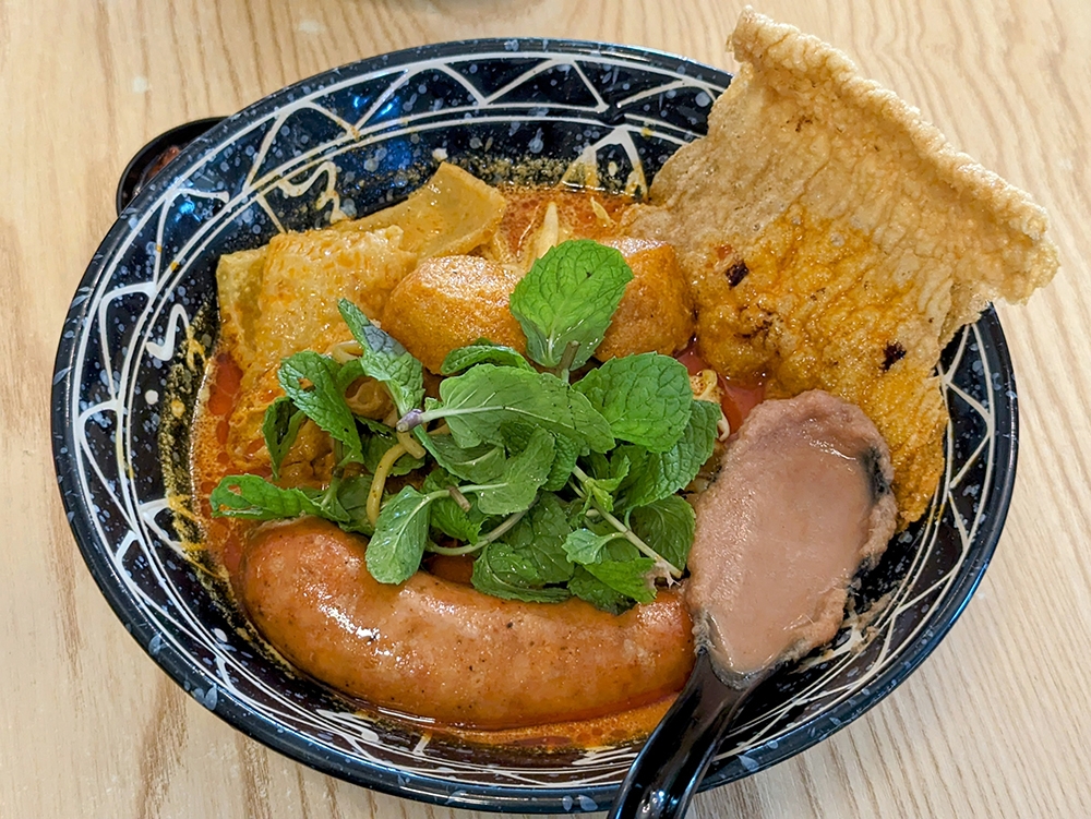 The ‘siham’ + chorizo pork sausage + honey BBQ ‘Nyonya curry laksa’ is a solid, if a little different, version of KL curry mee.