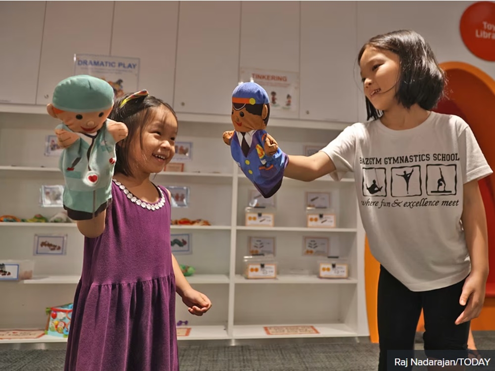 Andrew Tan’s daughters playing together with hand puppets at the Toy Library in Singapore May 27, 2024. — TODAY pic