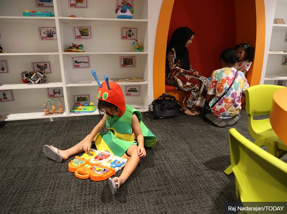 Andrew Tan’s daughter, four, dressed in a costume from the children’s book The Hungry Caterpillar. She is pictured here playing with an educational lock and latches toy at the Toy Library in Singapore May 27, 2024. — TODAY pic