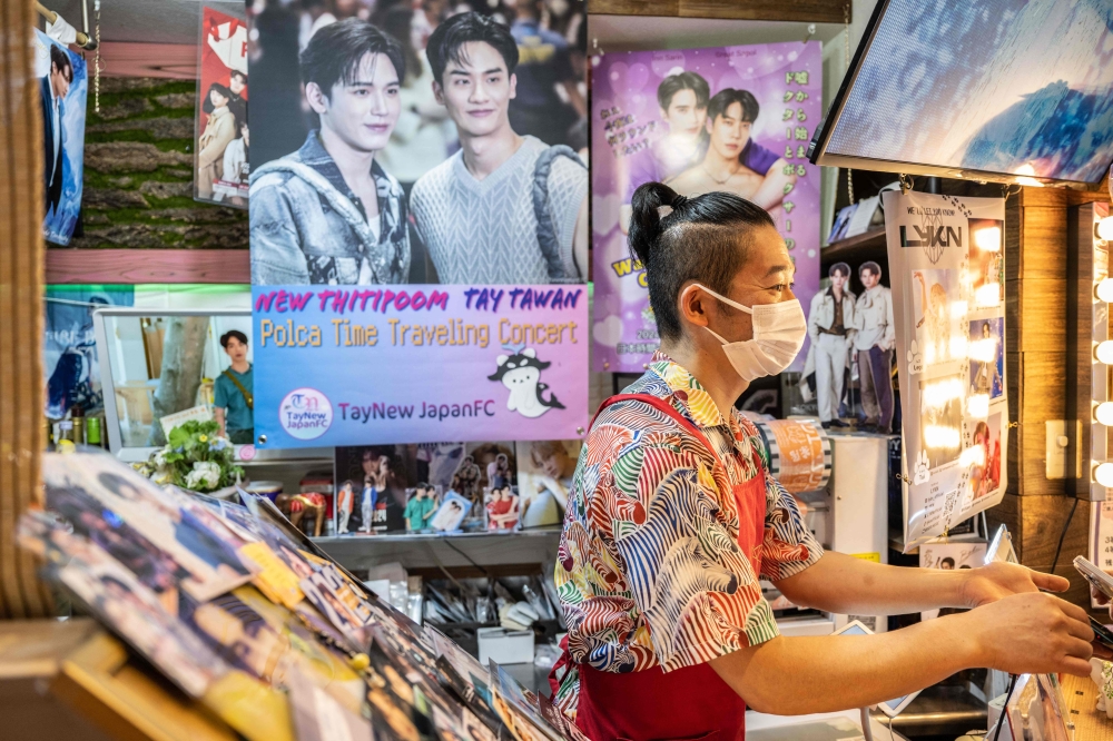 This picture taken on April 27, 2024 shows a member of staff serving customers at Tokyo No. 1 Sabo cafe in Tokyo, a tiny Thai-themed cafe in the Japanese capital that has become a hotspot for fans of boys’ love dramas. — AFP pic