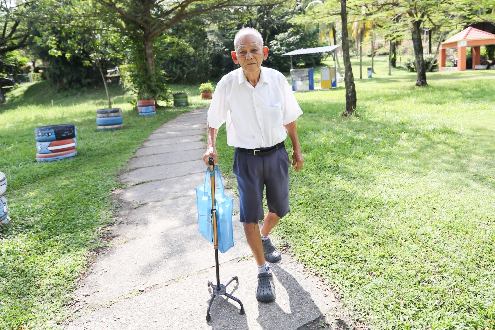 Clad in his white shirt and boys blue shorts, Lee heads to the park with his walking cane every Monday to Thursday morning. — Picture by Miera Zulyana