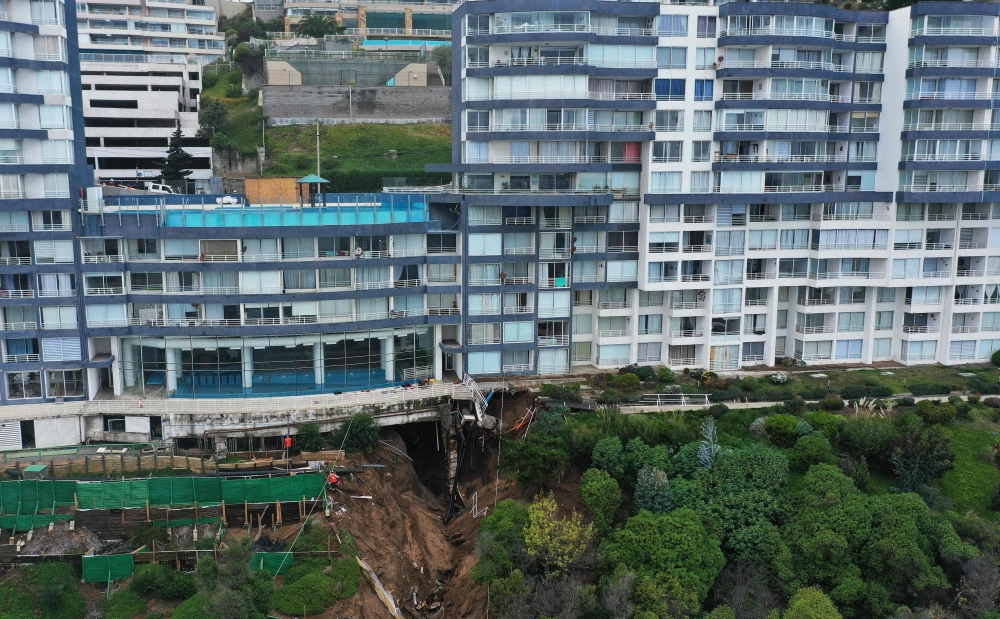 In the city of Vina del Mar, experts worked to save a 12-storey apartment building at risk of collapse after the rains caused a massive sinkhole underneath it. — AFP pic