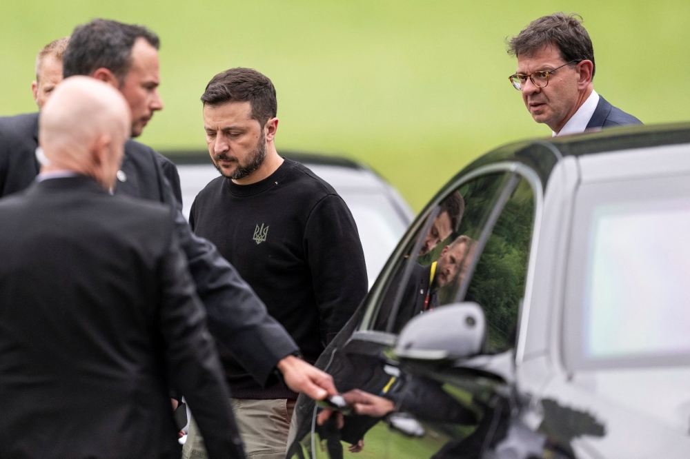 President of Ukraine, Volodymyr Zelenskiy, left, followed by Felix Baumann, Swiss Ambassador to Ukraine, right, steps toward a limousine after his landing in Obbuergen near the Buergenstock Resort, ahead the Summit on peace in Ukraine, in Stansstad near Lucerne, Switzerland, June 14, 2024. — Reuters pic