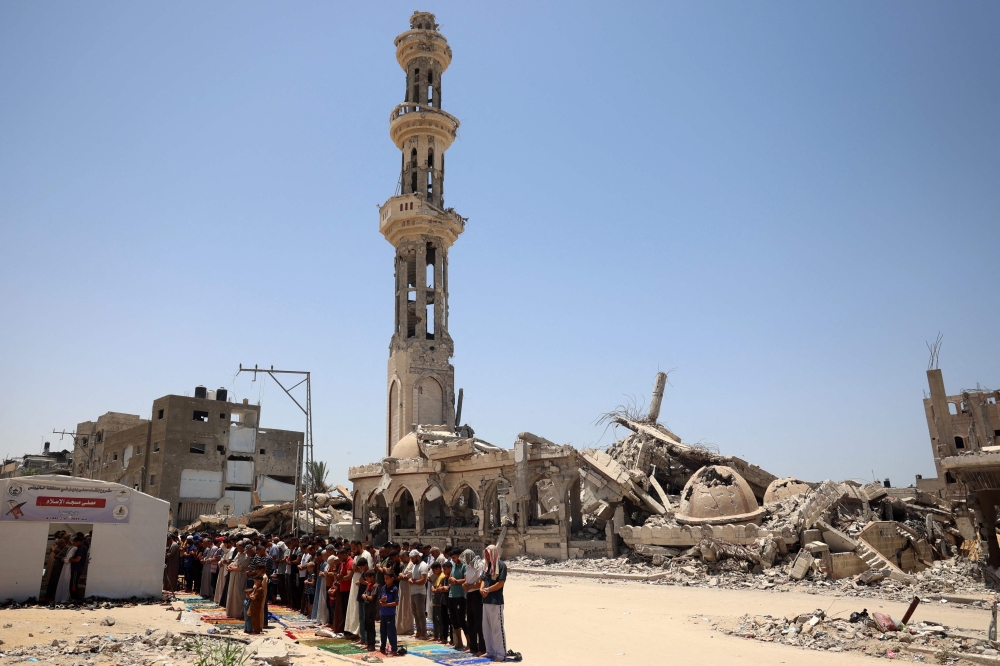 File photo of people performing the Friday noon prayer in front of a destroyed mosque in Khan Yunis in the southern Gaza Strip on June 14, 2024, amid the ongoing conflict between Israel and the Palestinian Hamas militant group. — AFP pic