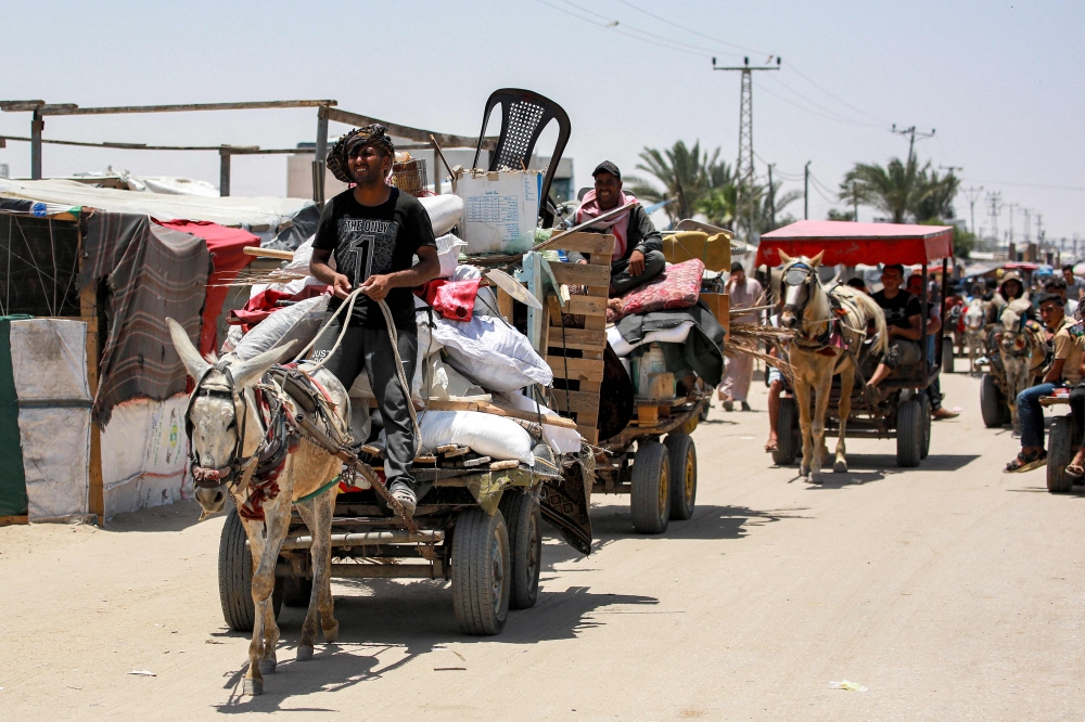 File photo of men driving animal-drawn carts loaded with items past the tents and shelters of people displaced by conflict in the western part of Rafah in the southern Gaza Strip on June 14, 2024 amid the ongoing conflict in the Palestinian territory between Israel and Hamas. — AFP pic