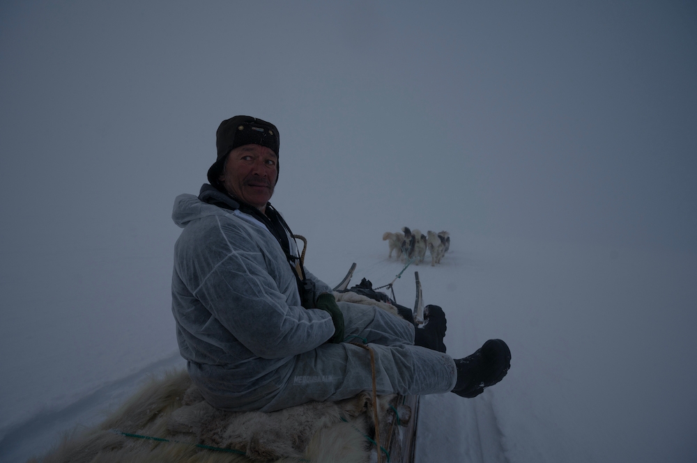 Inuit hunter Hjelmer Hammeken rides his dogs sled back to Ittoqqortoormiit at night. — AFP pic