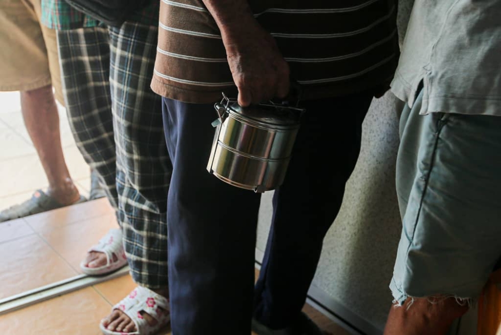 Recipients of Pertubuhan Amal Ai Xin Fan Tong are required to bring their own containers if they take away their meals. — Picture by Farhan Najib