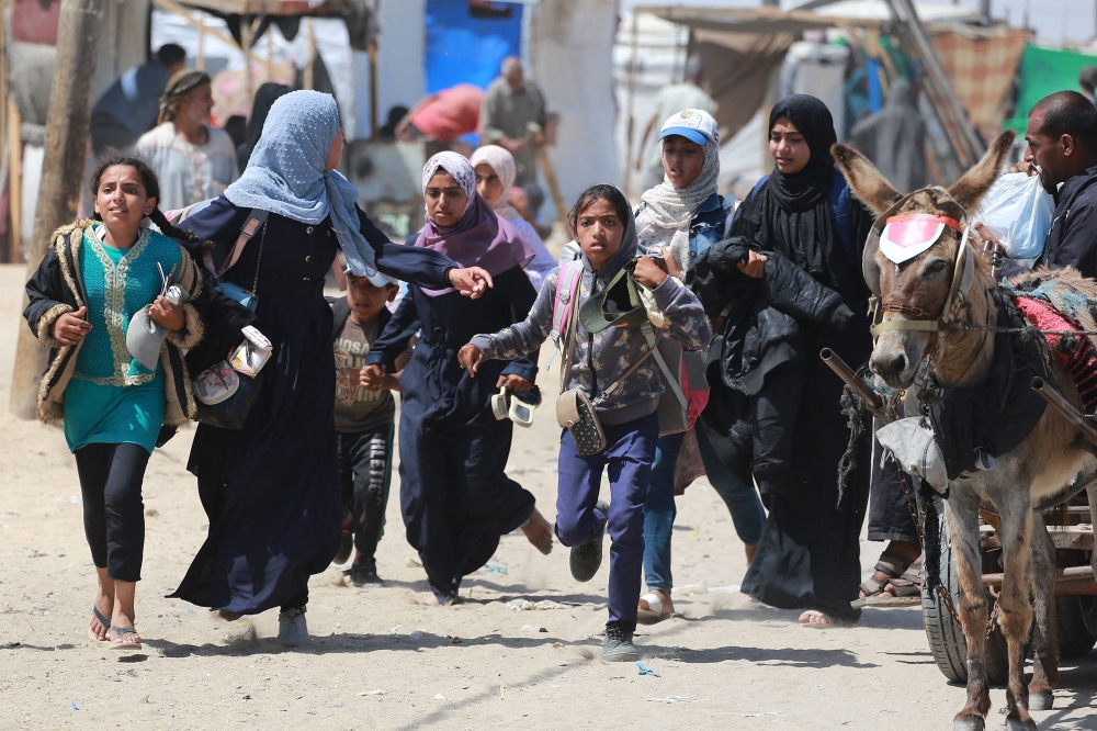 Palestinians run during as Israel bombs Rafah. — AFP pic