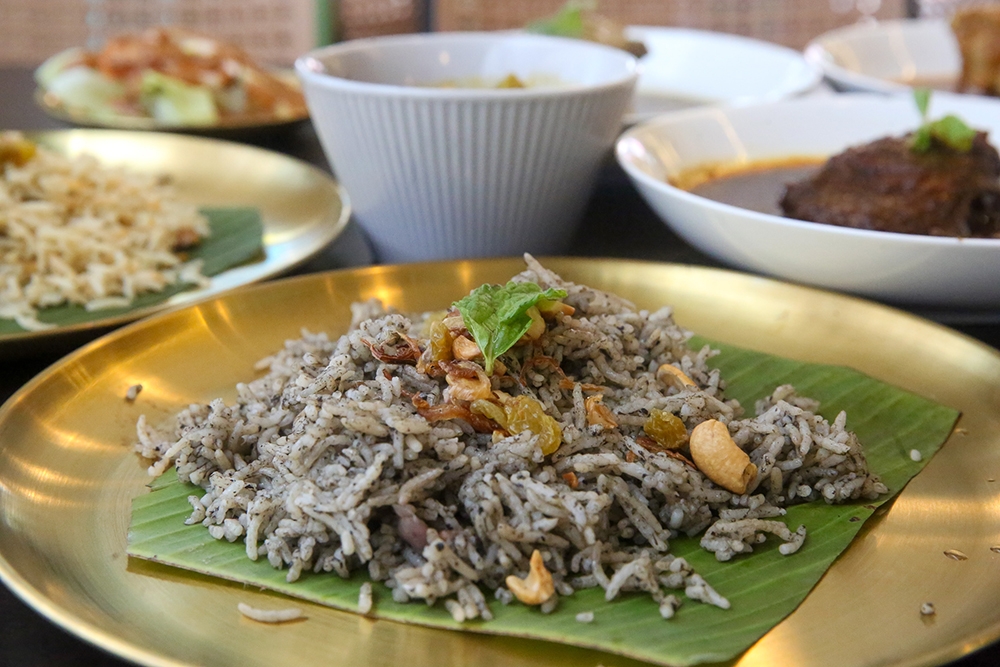 A portion of 'nasi lemuni' — the rice gains its dark purplish-green hue from 'daun lemuni', which is rarely grown outside of the north.