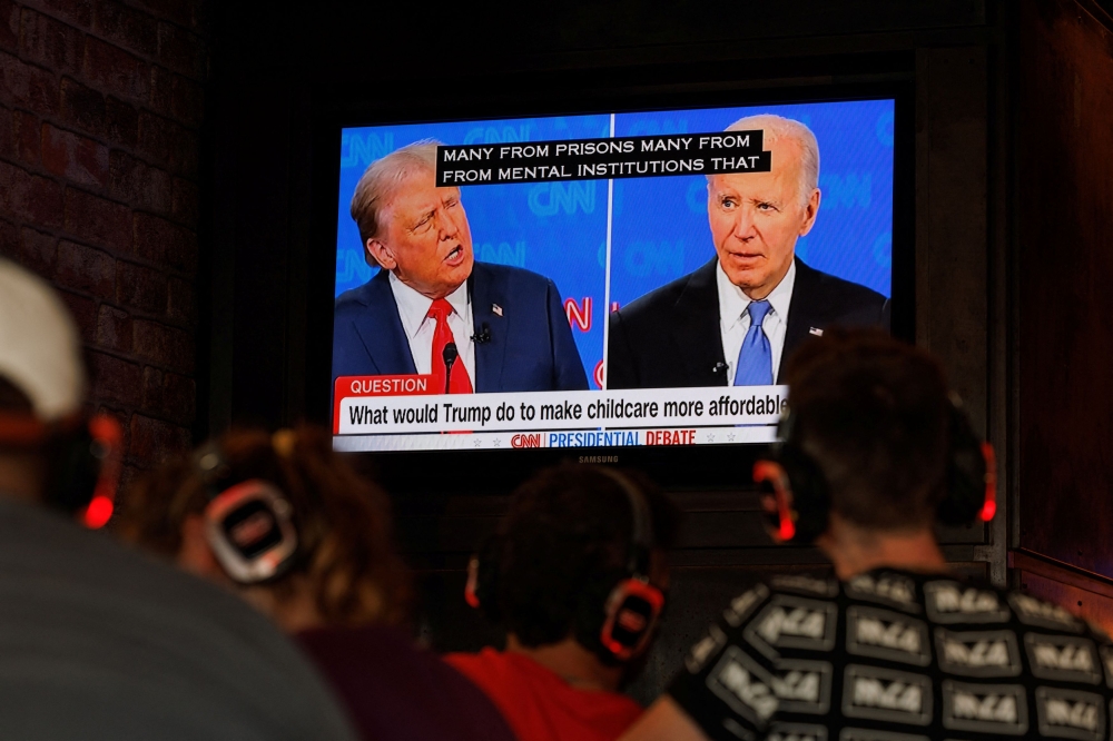 People watch the first Presidential debate between U.S. President Joe Biden and Republican candidate, former President Donald Trump, from a tavern in San Diego, California June 27, 2024. — Reuters pic