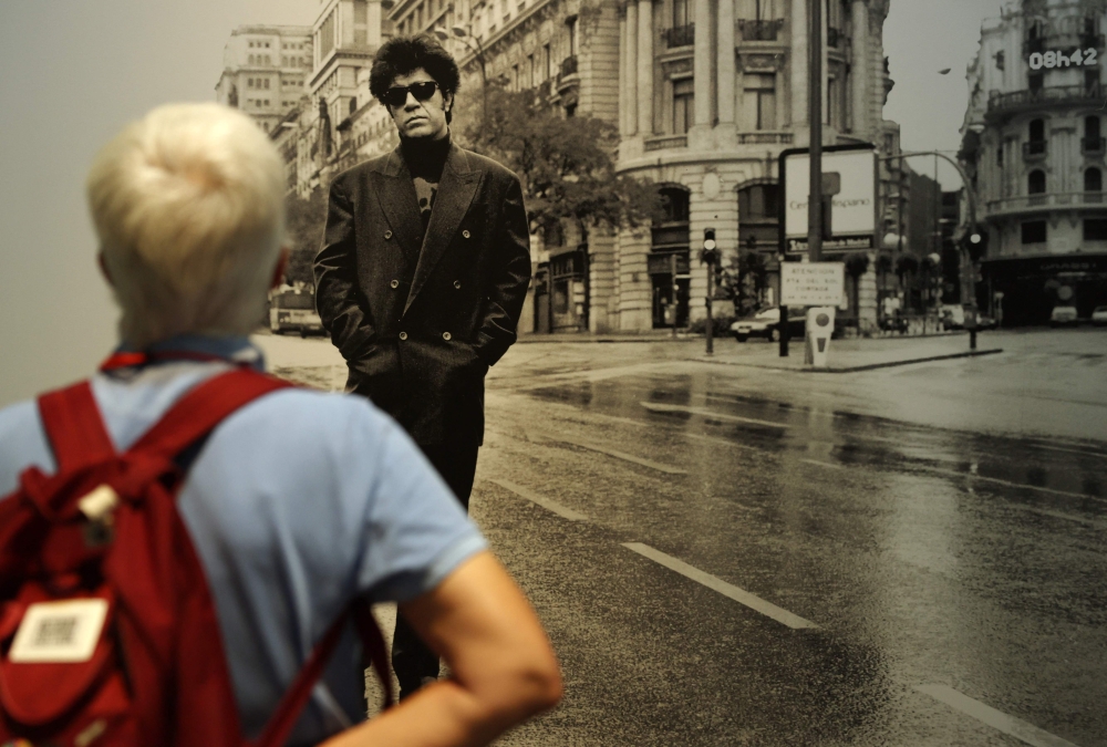 A visitor observes a black and white photograph showing Spanish filmmaker Pedro Almodovar posing in Gran Via street, in Madrid, displayed as part of the exhibition ‘Madrid, Chica Almodovar’ (Madrid, Almodovar Girl), at the Centro Condeduque in Madrid June 20, 2024. — AFP pic